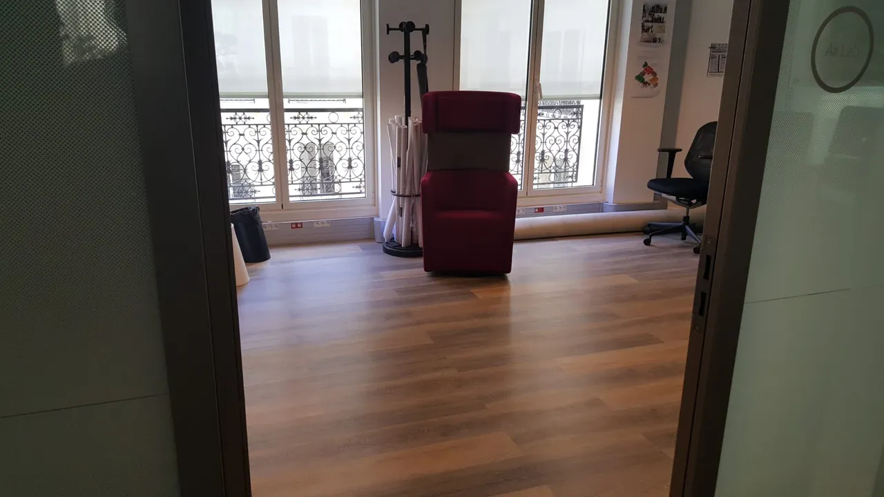 Espace de bureaux aménagé avec parquet et coin salon