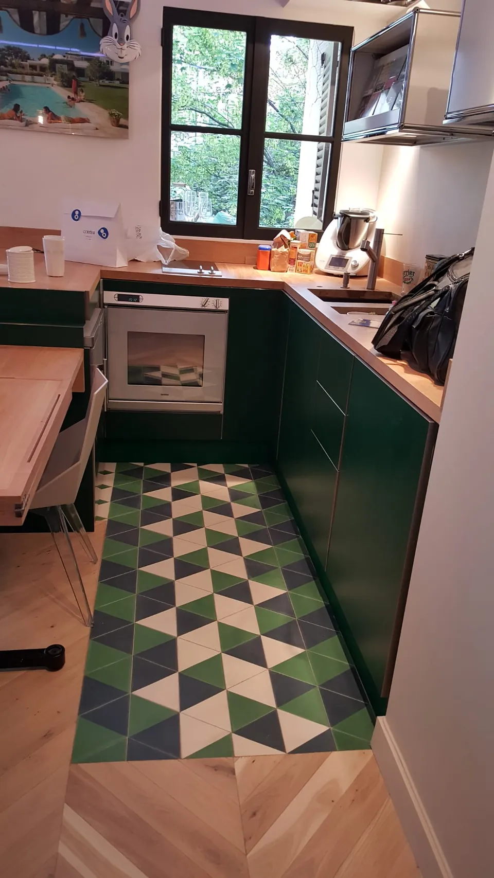 Cuisine laquée verte avec sol en carreaux de ciment géométriques et fenêtre