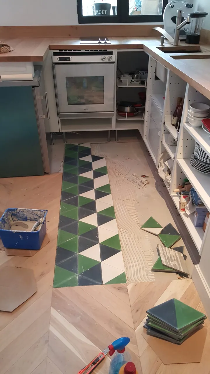 Pose de carreaux de ciment sur un chantier de cuisine