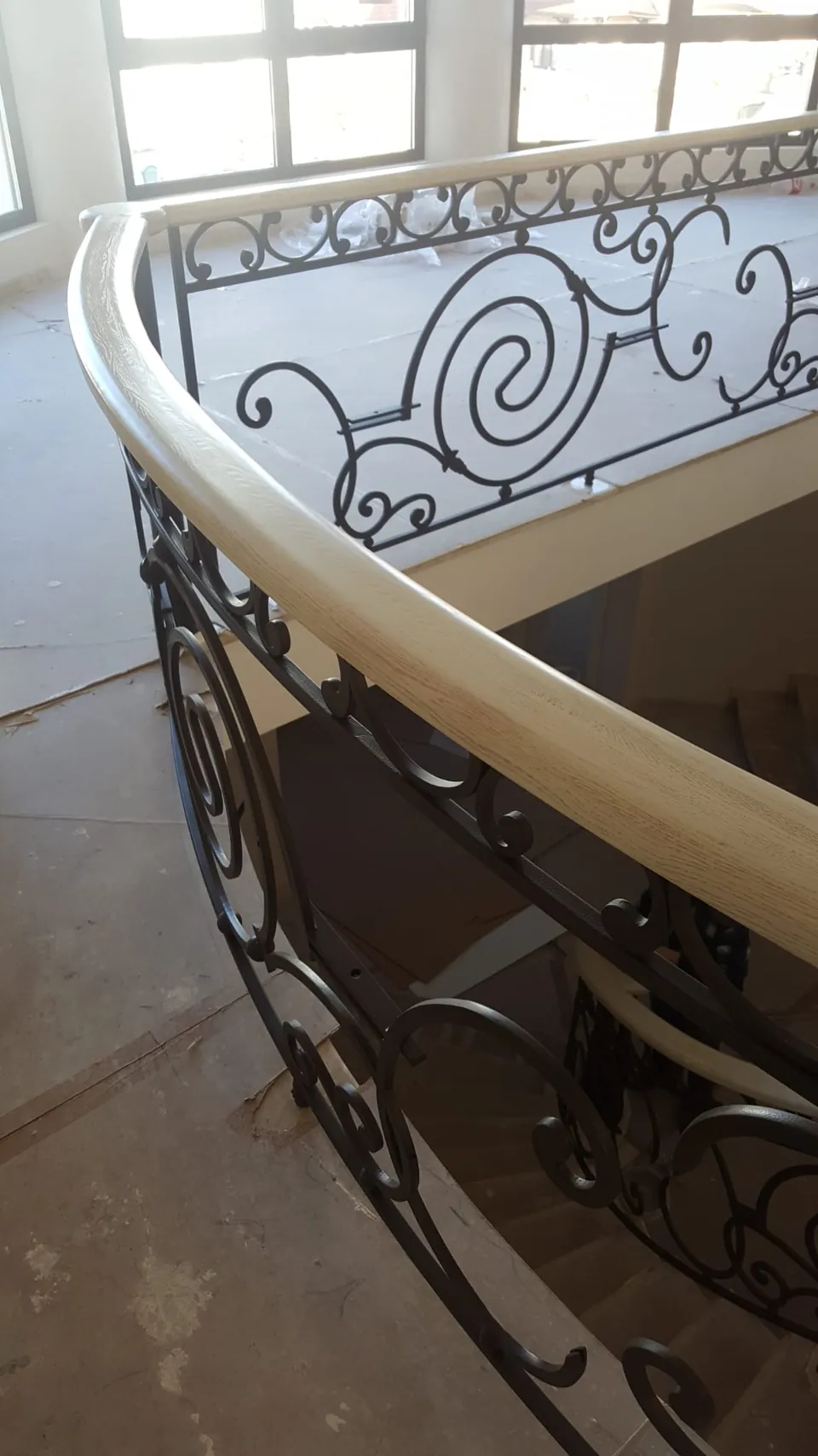 Rampe en fer forgé à volutes le long d'un escalier tournant en pierre