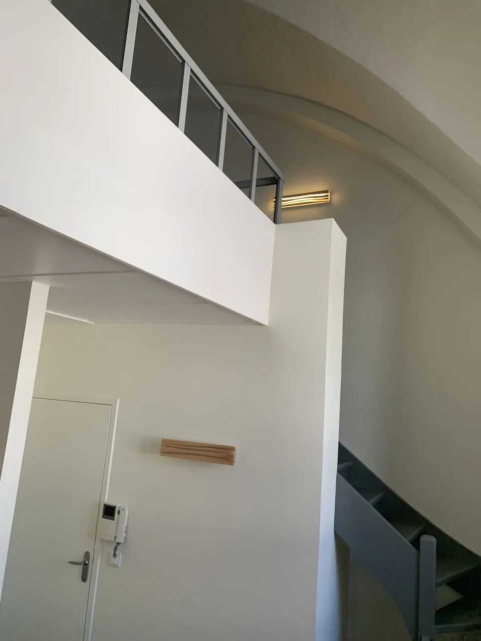 Mezzanine sous voûte avec garde-corps métallique et éclairage indirect