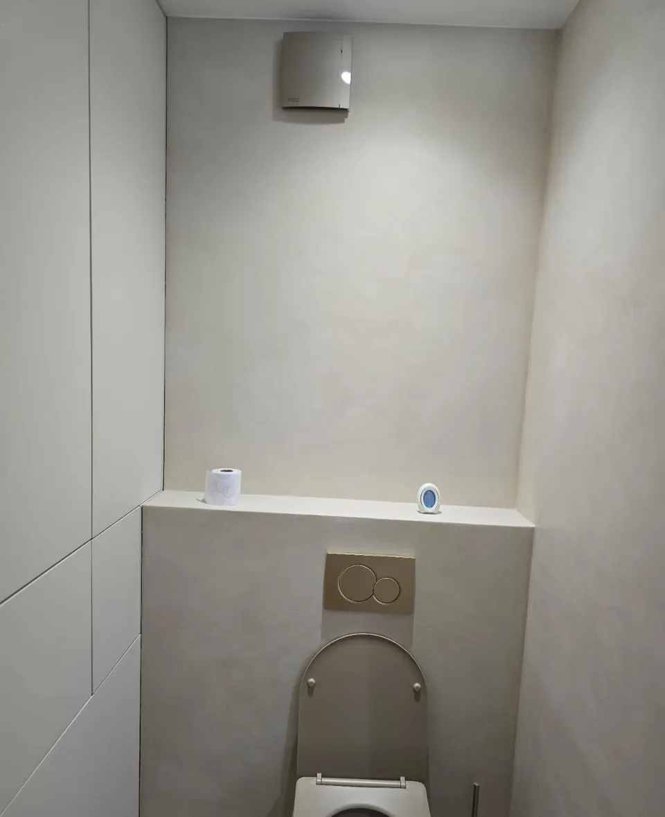 WC suspendu avec habillage en béton ciré et niche de rangement